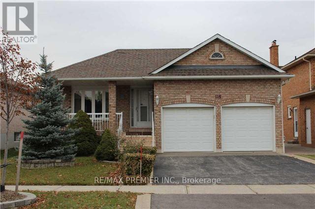 A brick house with a garage door is for sale.