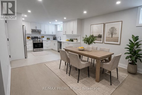 A dining room with a table set for two and a kitchen in the background.
