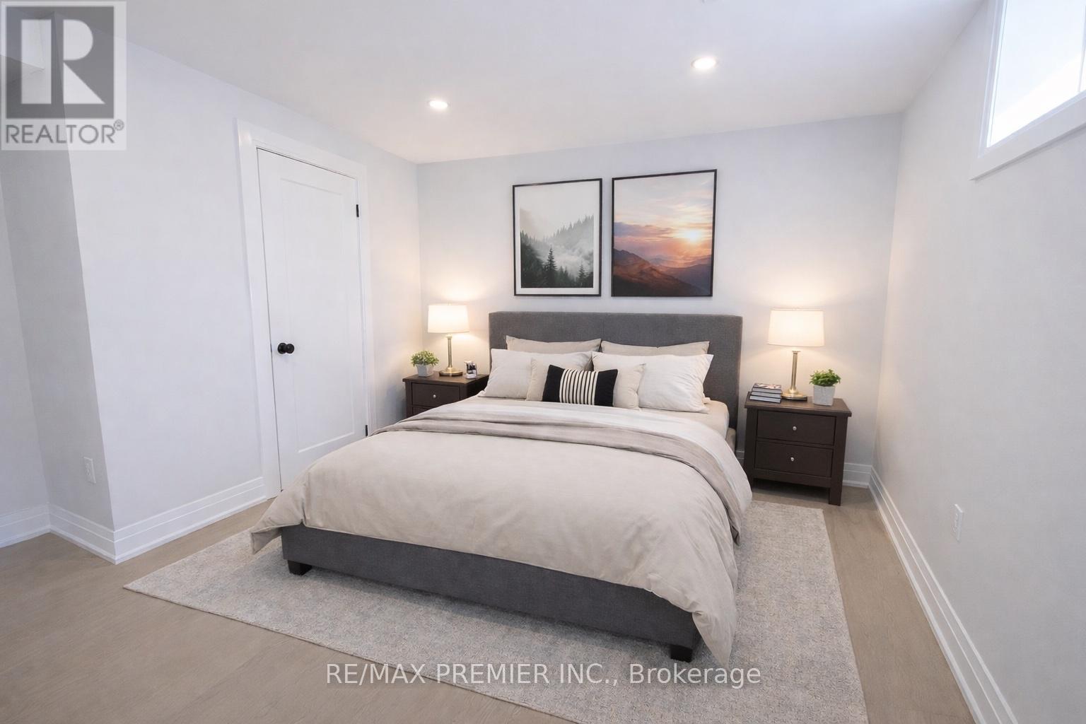 A bedroom with a large bed and two framed pictures on the wall.