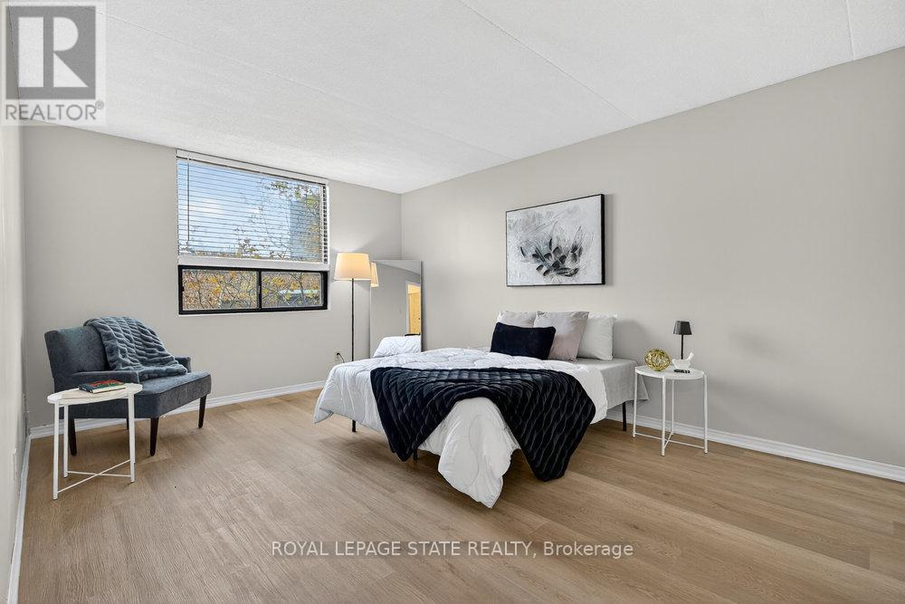 A bedroom with a bed, chair, and lamp.