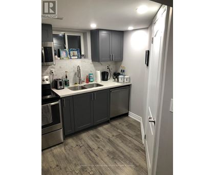 A kitchen with a sink, stove, and cabinets.