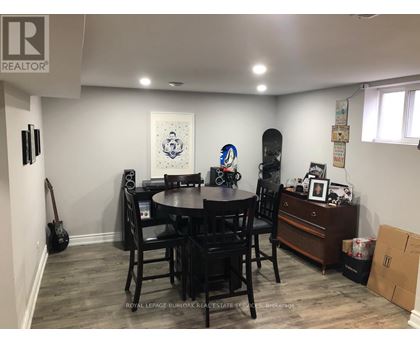 A dining room with a guitar and a skateboard.