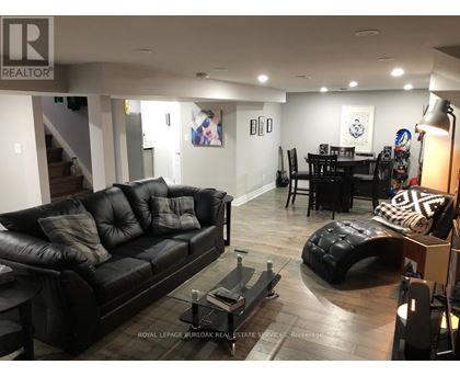 A living room with a black leather couch and a coffee table.
