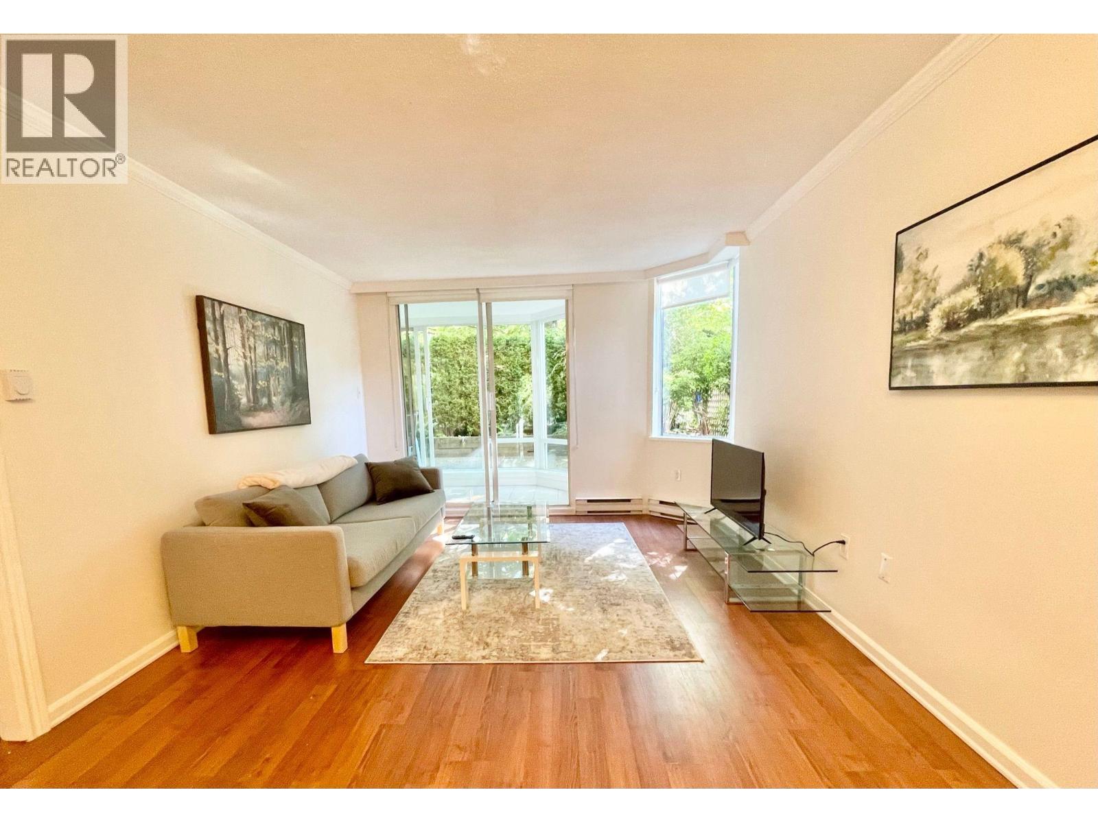 A living room with a couch, a coffee table, and a television.
