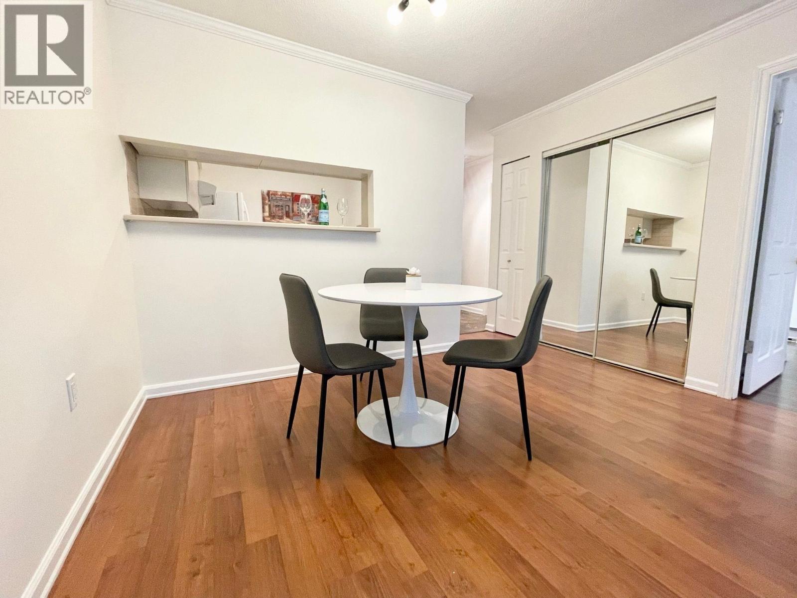 A dining room with a table and chairs.