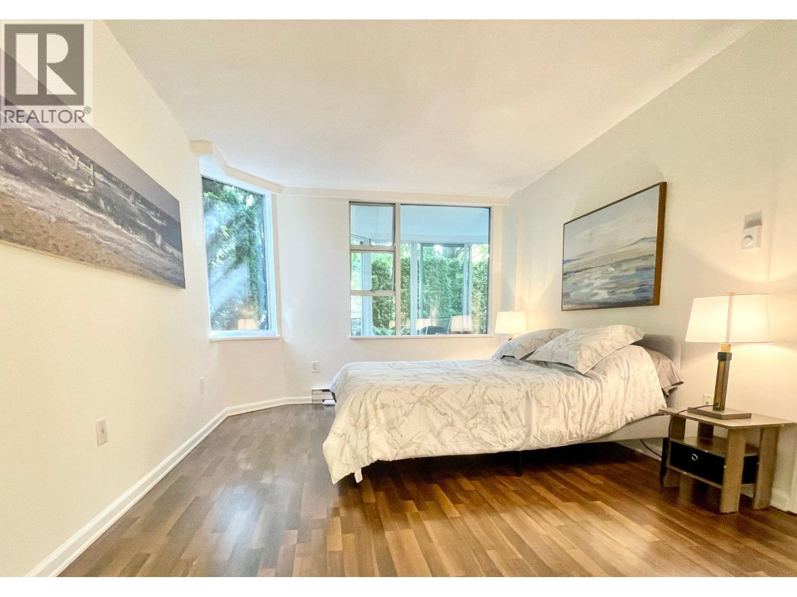 A bedroom with a large bed and a painting on the wall.