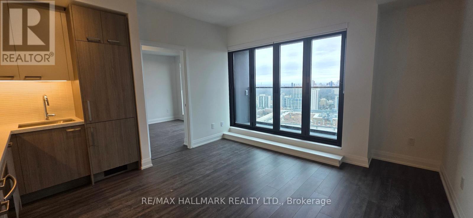 A large empty room with a view of the city through the windows.