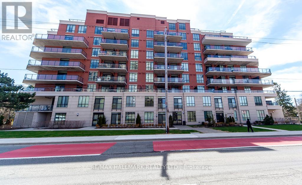 A red and white apartment building with a person standing in front.