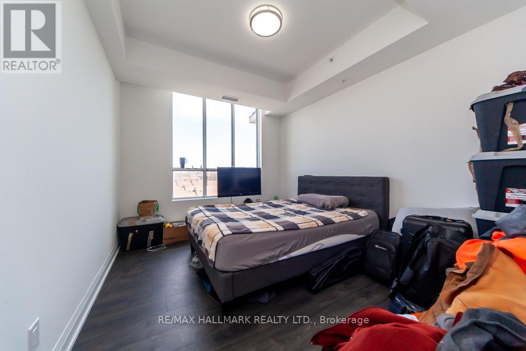 A bedroom with a bed, luggage, and a window.