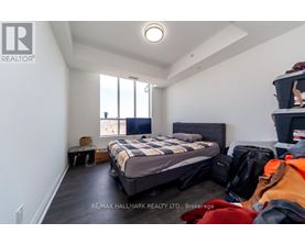 A bedroom with a bed, luggage, and a window.