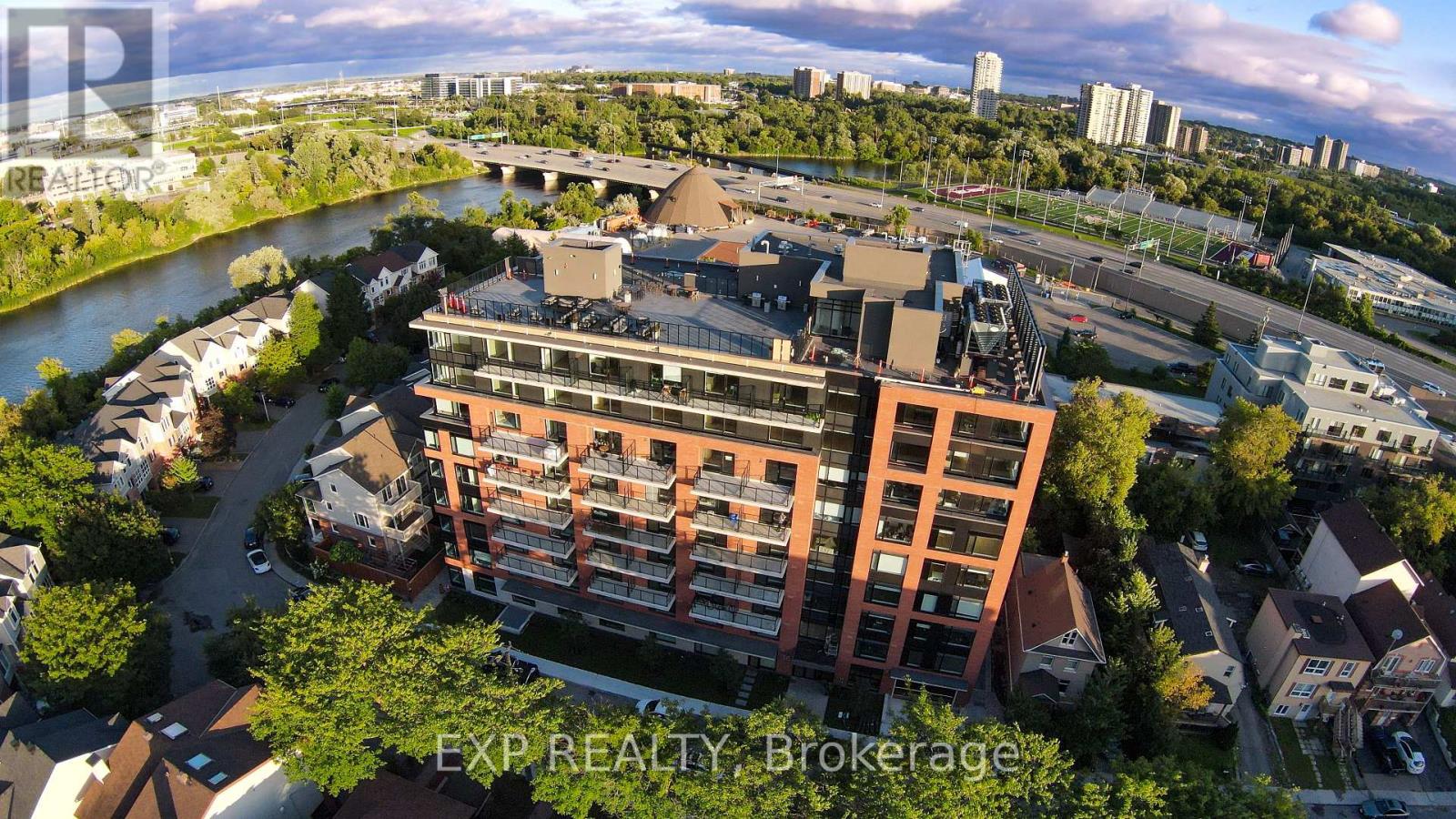 An aerial view of a cityscape with a large building in the foreground and a river running through the middle.