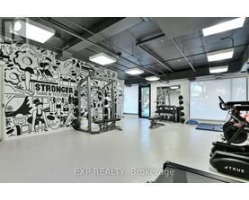 A gym with a wall mural that says "STRONGER THAN YESTERDAY" and exercise equipment.