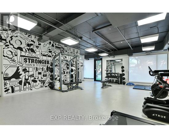 A gym with a wall mural that says "STRONGER THAN YESTERDAY" and exercise equipment.