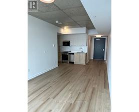 A kitchen with wooden floors and white walls.