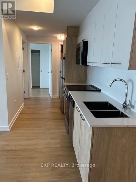 A kitchen with wooden floors and white cabinets.