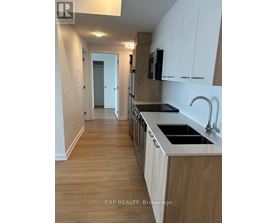 A kitchen with wooden floors and white cabinets.