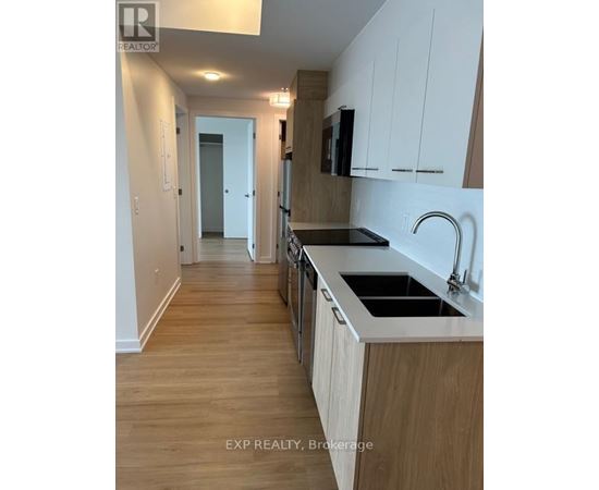 A kitchen with wooden floors and white cabinets.