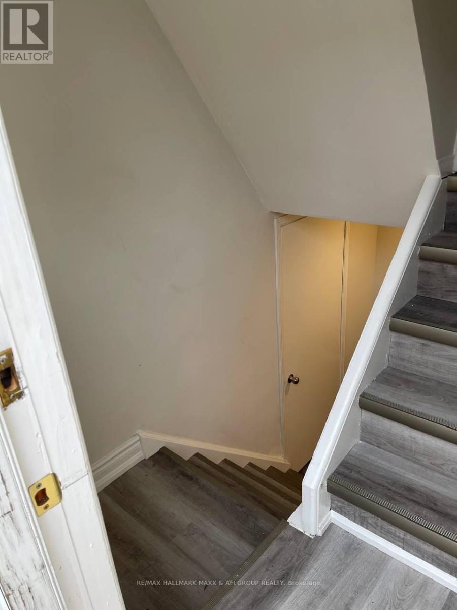 A staircase with a white door on the left and a light on the right.