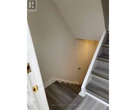 A staircase with a white door on the left and a light on the right.
