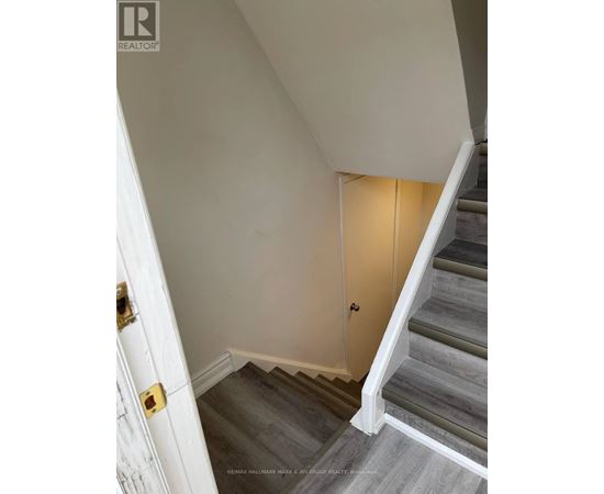 A staircase with a white door on the left and a light on the right.