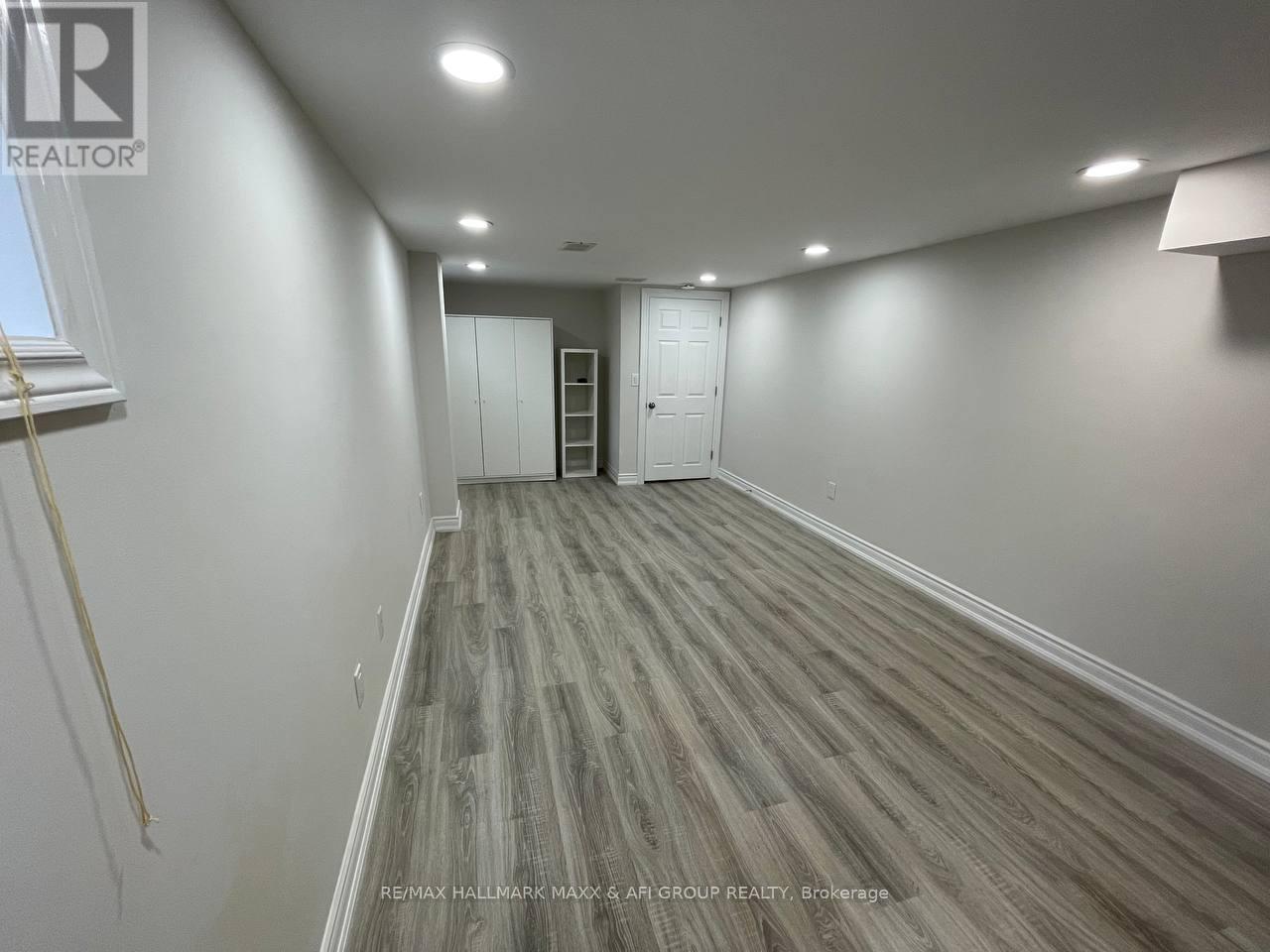 A room with wooden flooring and white walls.