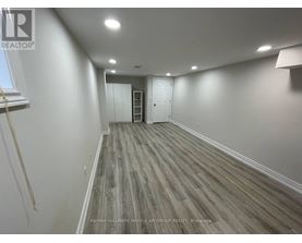 A room with wooden flooring and white walls.
