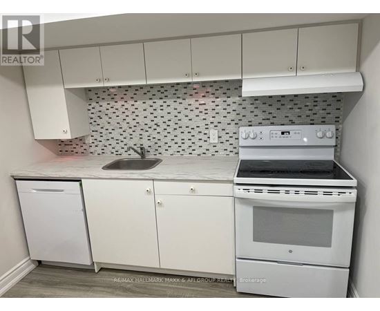 A white kitchen with a Brokerage stove top oven.