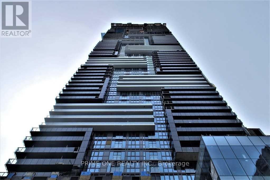 A tall building with a glass facade and a logo of "Prime One Realty Inc." on the side.