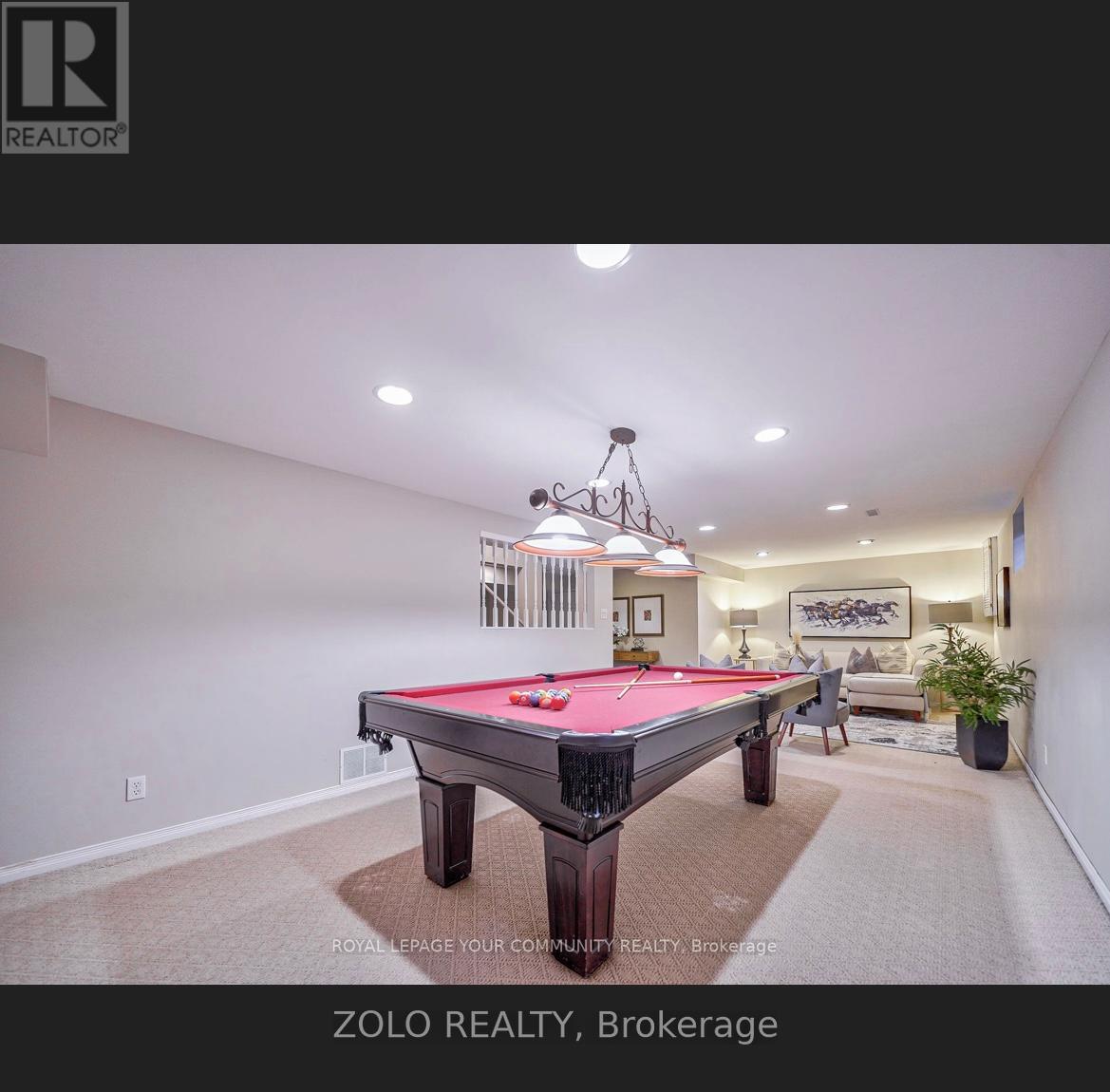 A pool table in a room with a chandelier and a painting on the wall.