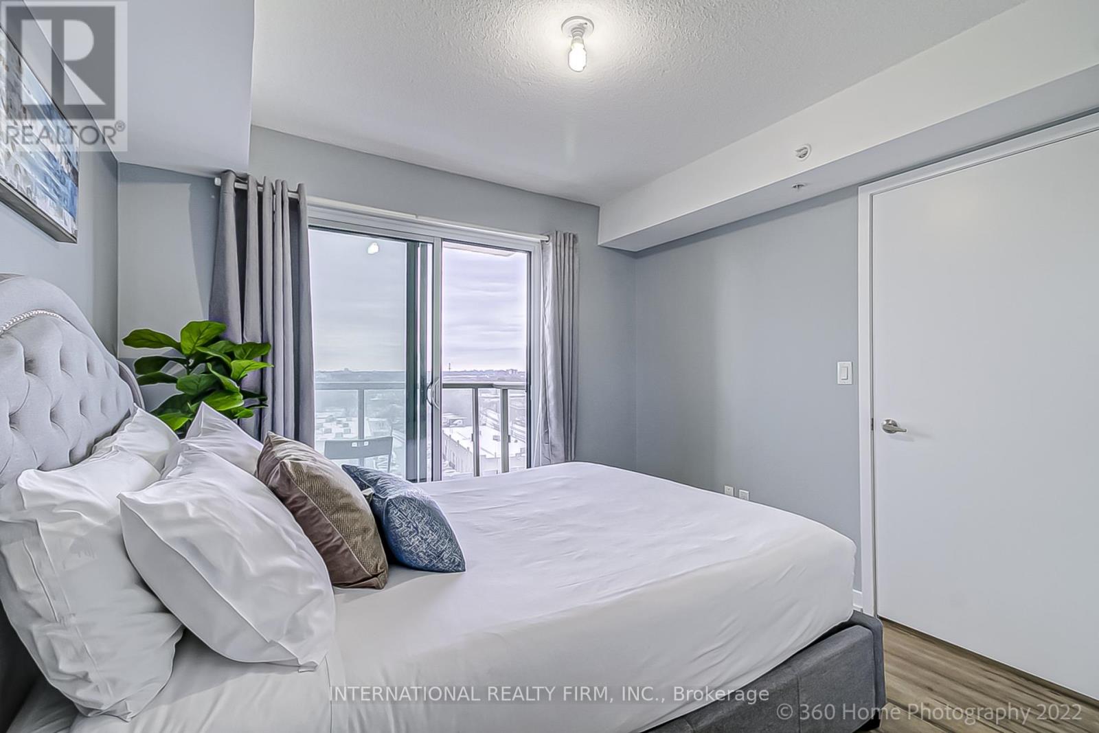 A bedroom with a large bed and a view of the balcony.