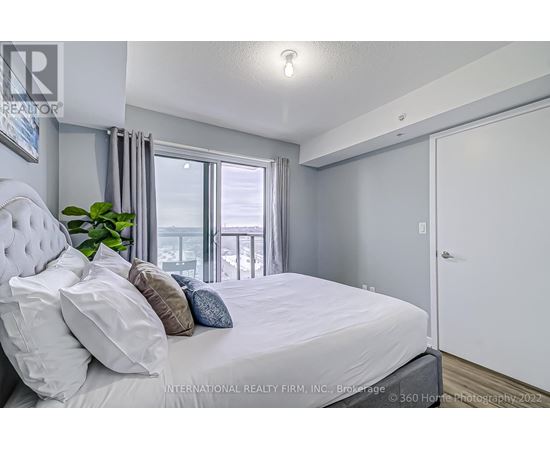 A bedroom with a large bed and a view of the balcony.