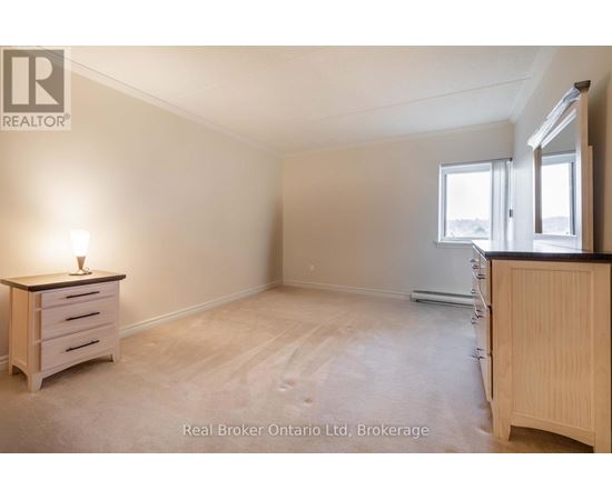 A bedroom with a dresser and a window.