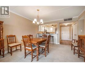 A dining room with a wooden table and chairs.