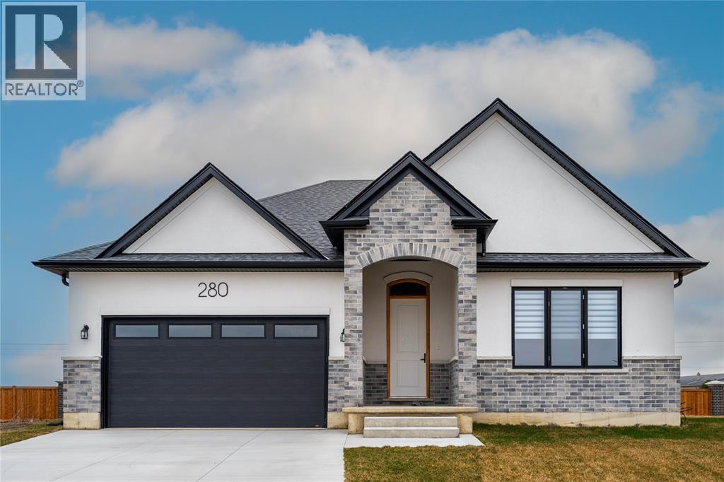 A modern house with a stone facade and a black garage door.