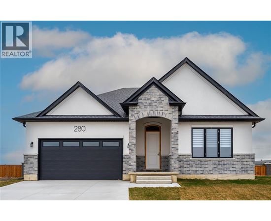 A modern house with a stone facade and a black garage door.