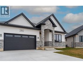 A modern house with a stone pillar entrance and a black garage door.