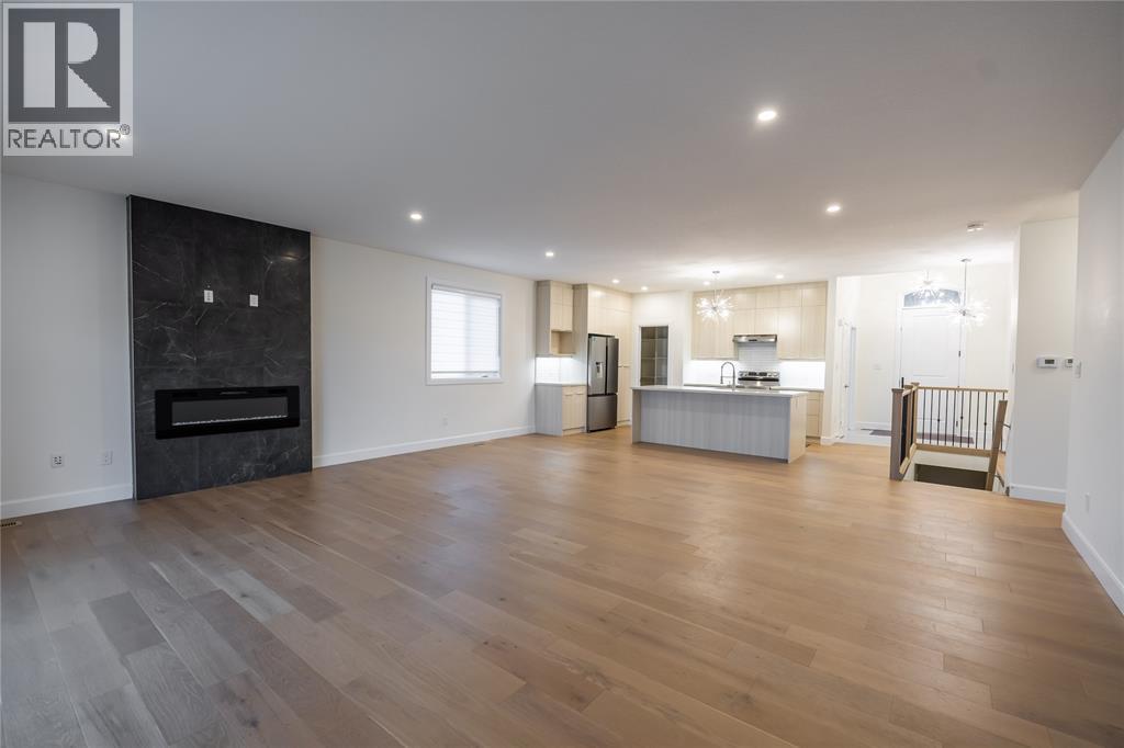 A spacious living room with a fireplace and hardwood floors.