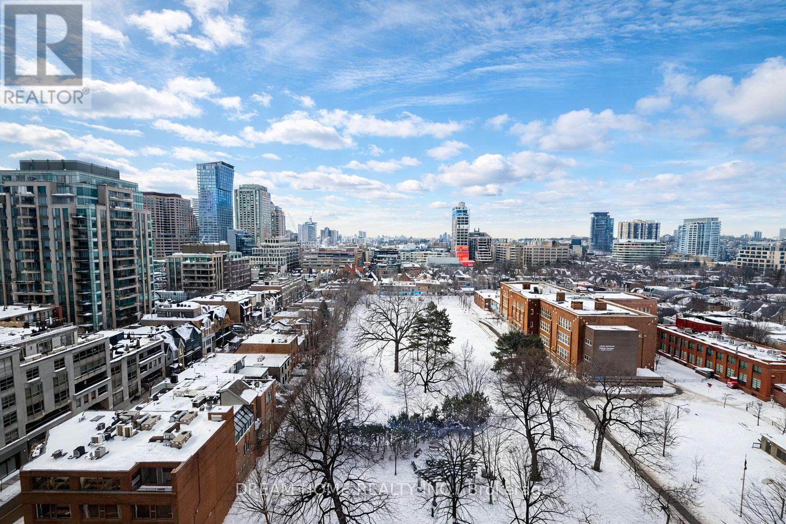 A cityscape with buildings and trees covered in snow.