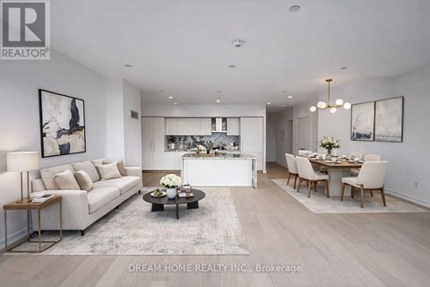 A modern living room with a white sofa, a coffee table, and a dining table set up.