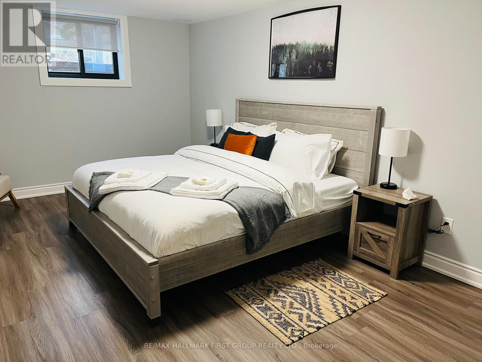 A bedroom with a large bed and a wooden nightstand.