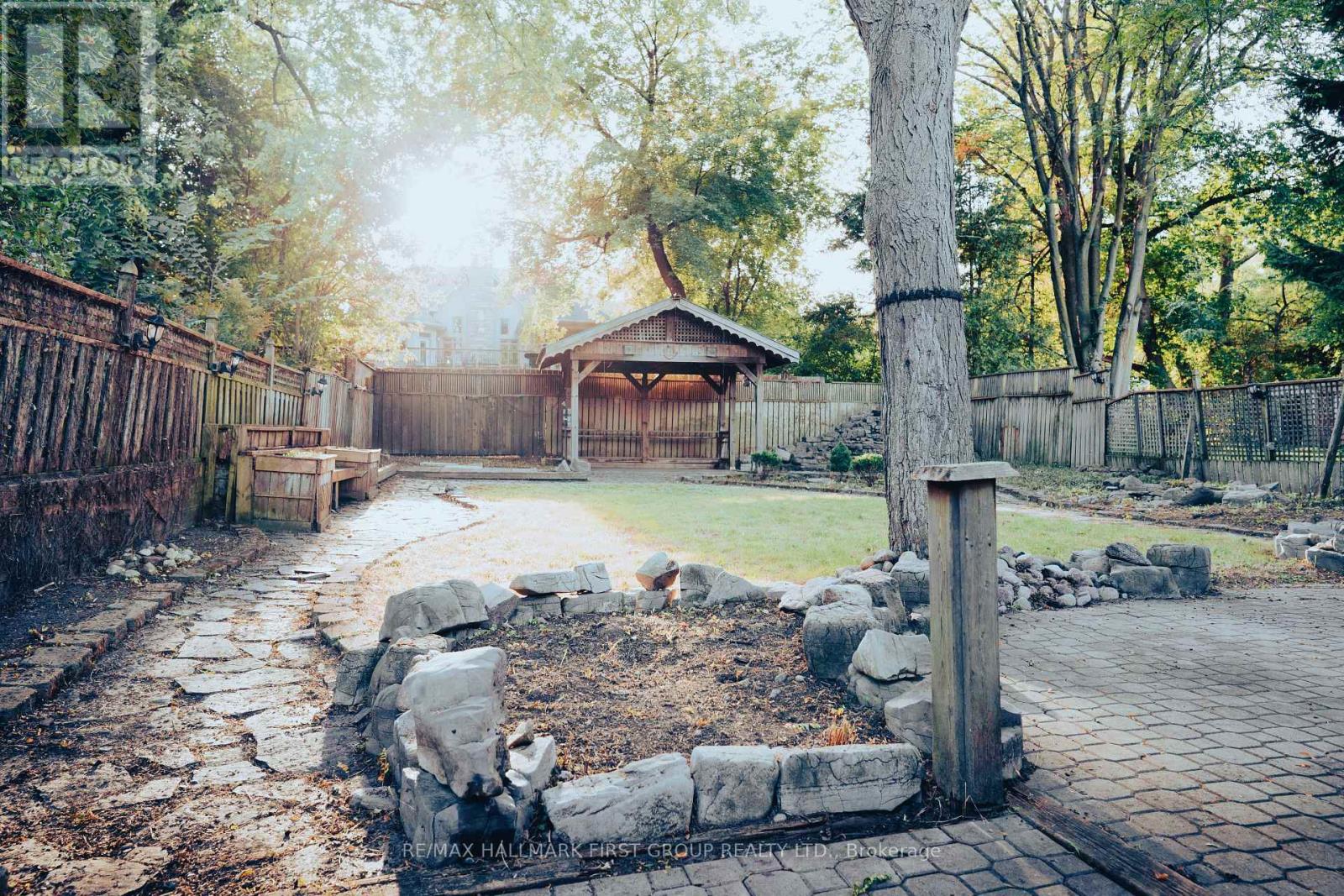 A backyard with a stone pathway and a gazebo.