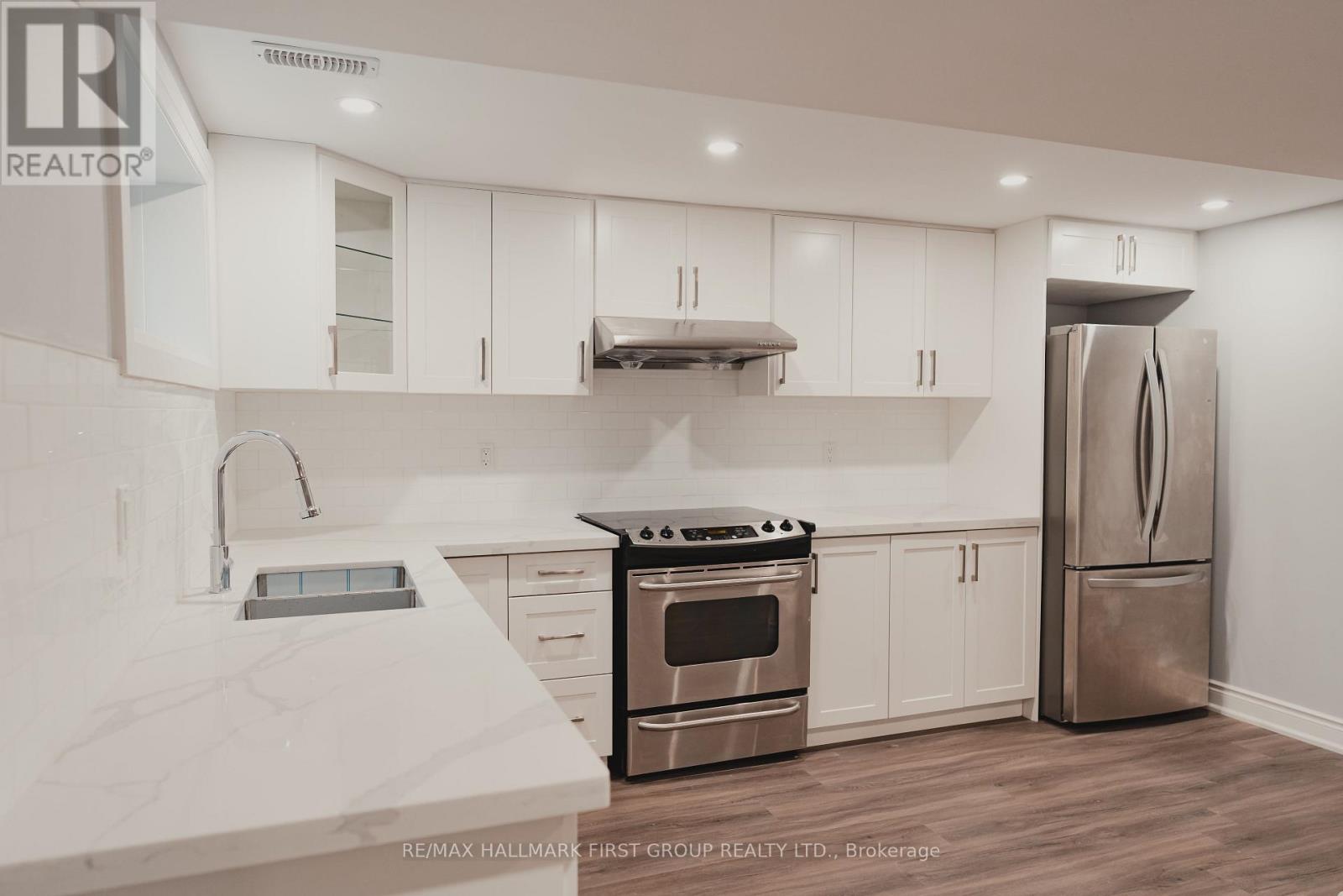 A modern kitchen with white cabinets and stainless steel appliances.