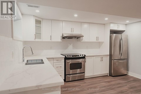 A modern kitchen with white cabinets and stainless steel appliances.