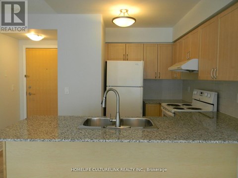 A kitchen with a sink and a refrigerator.