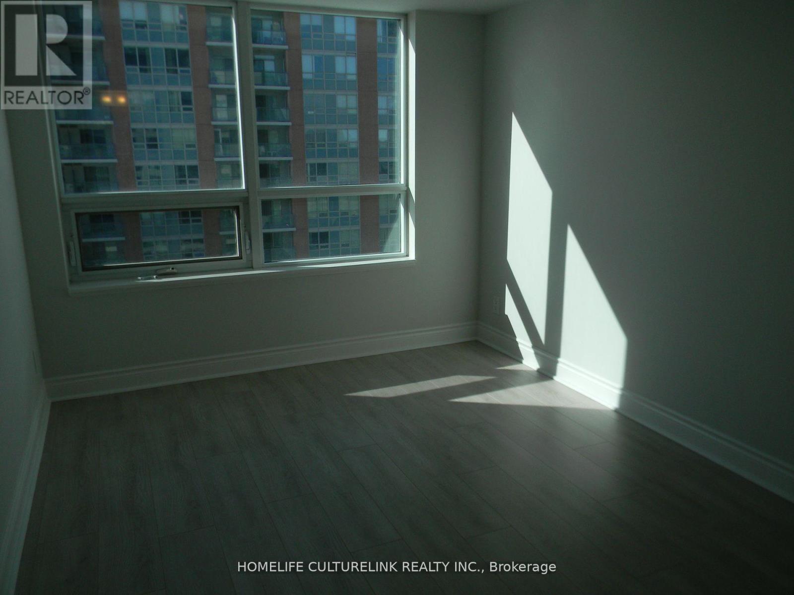 A room with a window showing a building outside.