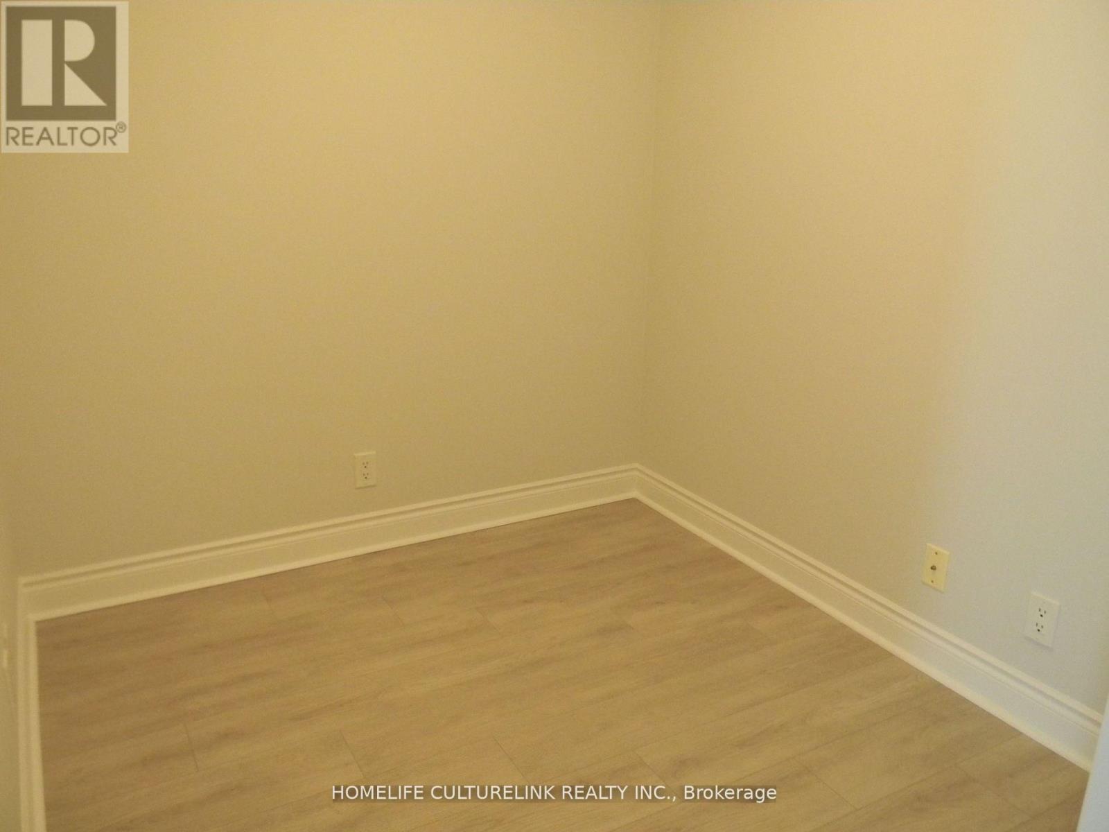A room with wooden flooring and white walls.