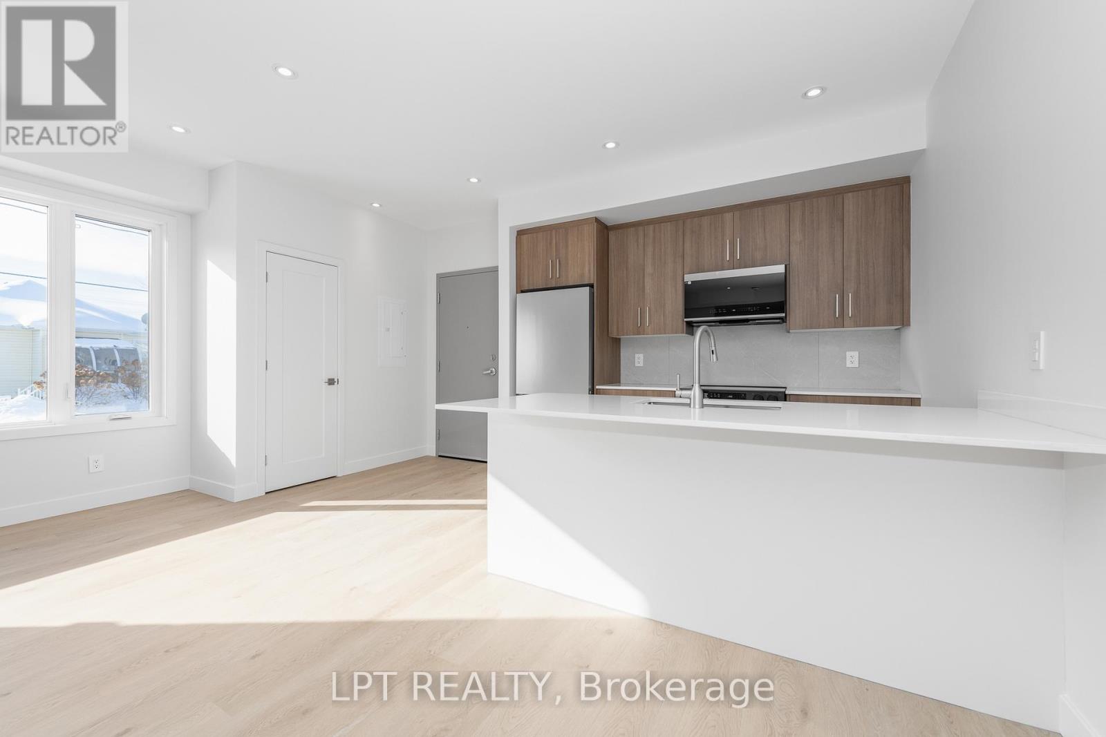 A spacious kitchen with wooden cabinets and a stainless steel refrigerator.