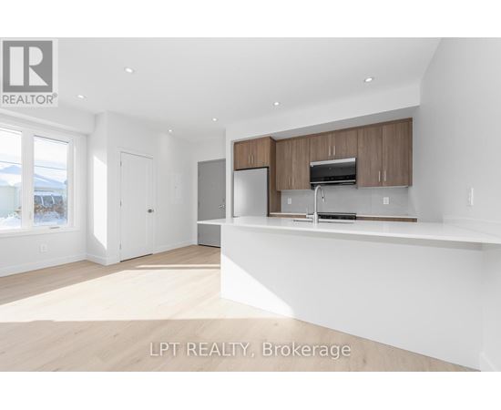 A spacious kitchen with wooden cabinets and a stainless steel refrigerator.