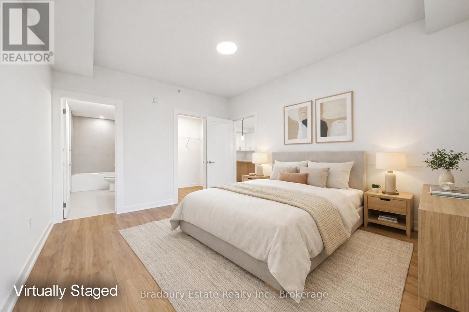 A bedroom with a large bed and a nightstand with a lamp.