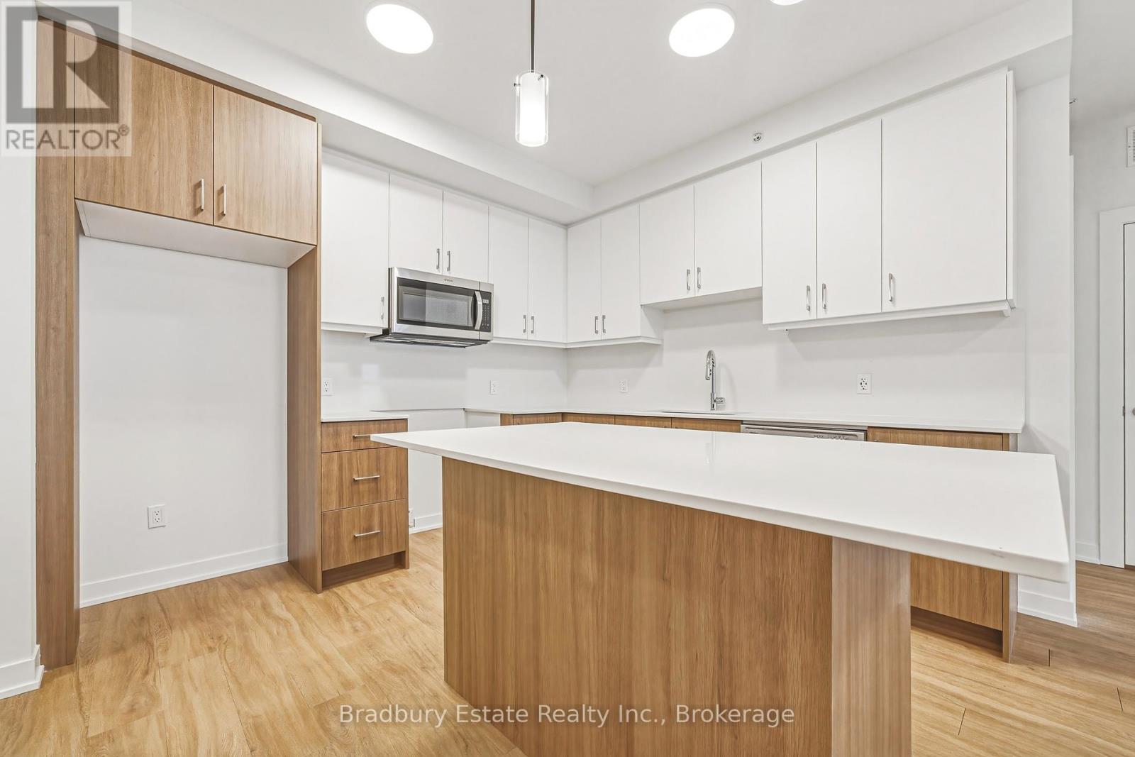 A kitchen with white cabinets and a wooden island.
